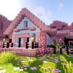 A pink, cherry wood Minecraft house design built in a cherry grove biome.