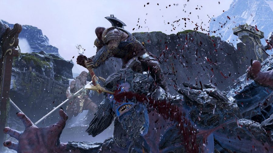 Kratos trying to pull his axe out of a beast's head in our God of War PC review